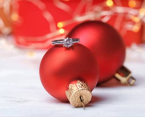 engagement ring in front of Christmas presents